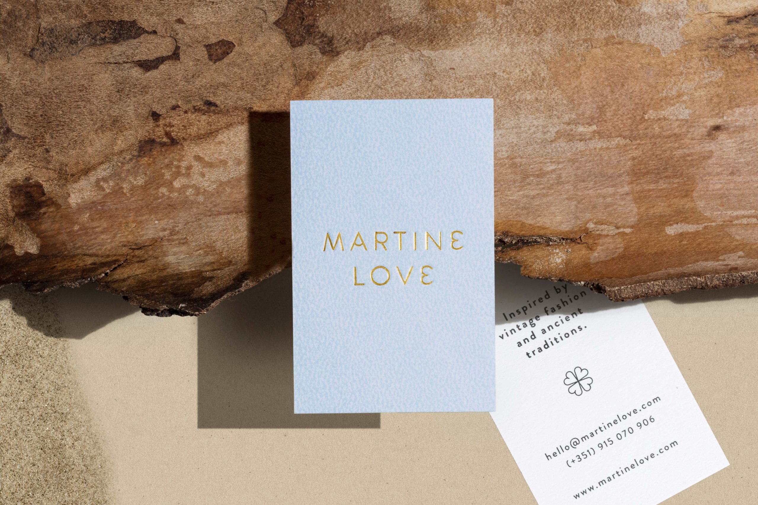 Martine Love business cards over tree trunk.